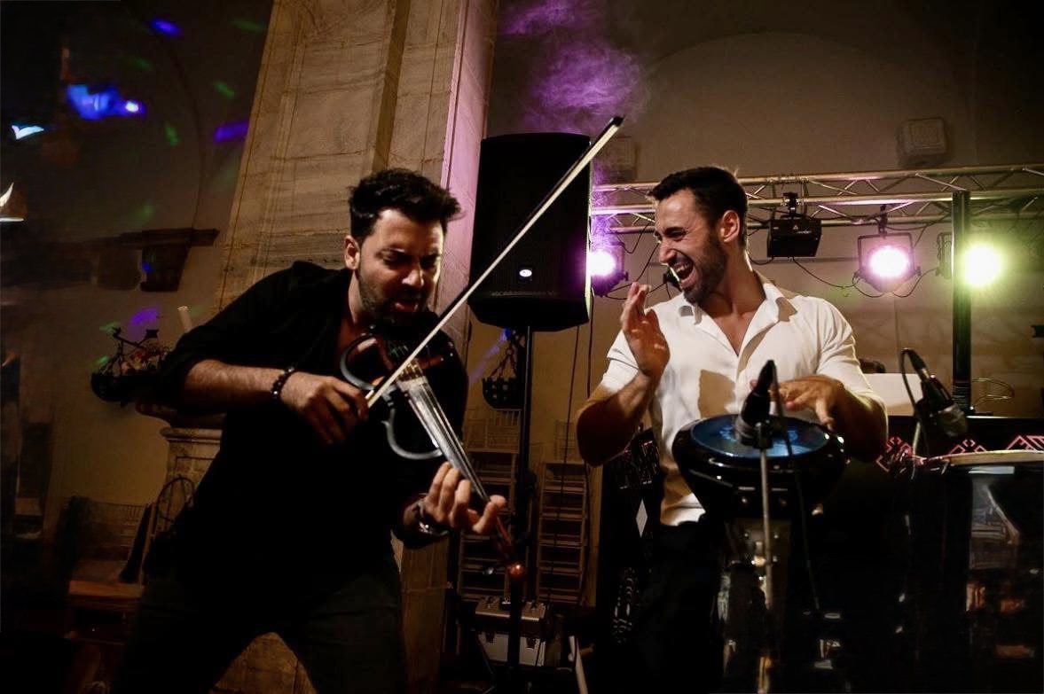 Percusionista en vivo durante barra libre con violín y saxofón