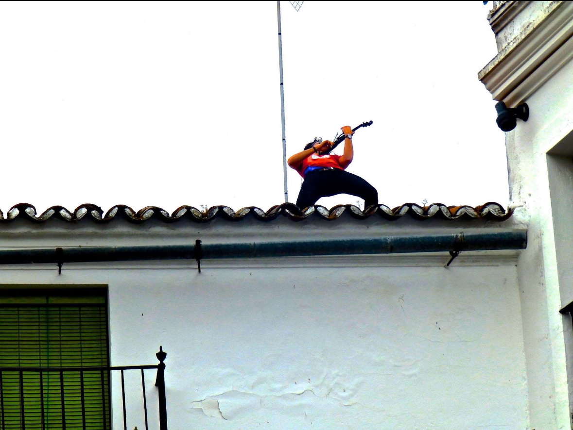 Lolo Alonso tocando el violín desde un tejado en Zafra con perspectiva desde abajo